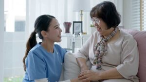 Care staff talking with an older adult while reviewing a personalized care plan in a comfortable residential setting.