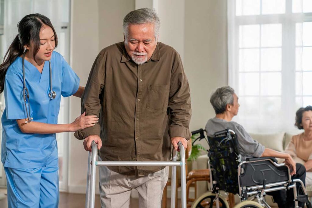 Older adult and family member arrange photographs and personal belongings in a bright assisted living room.