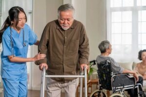 Older adult and family member arrange photographs and personal belongings in a bright assisted living room.